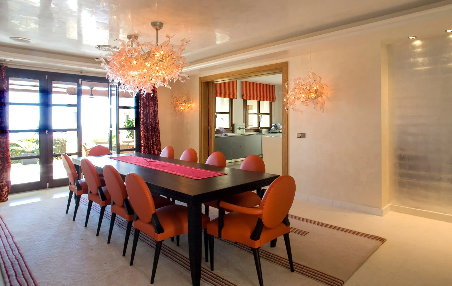 Dining room with orange chairs and crystal chandelier