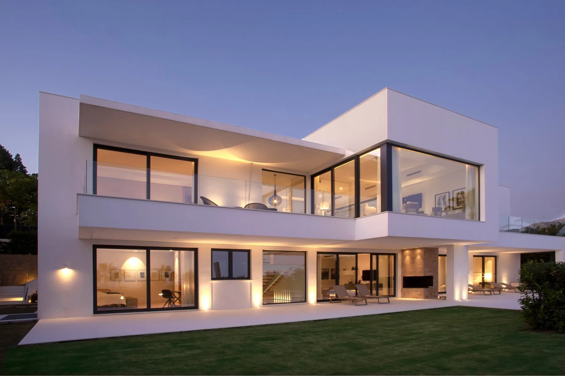Fachada blanca de la villa al anochecer