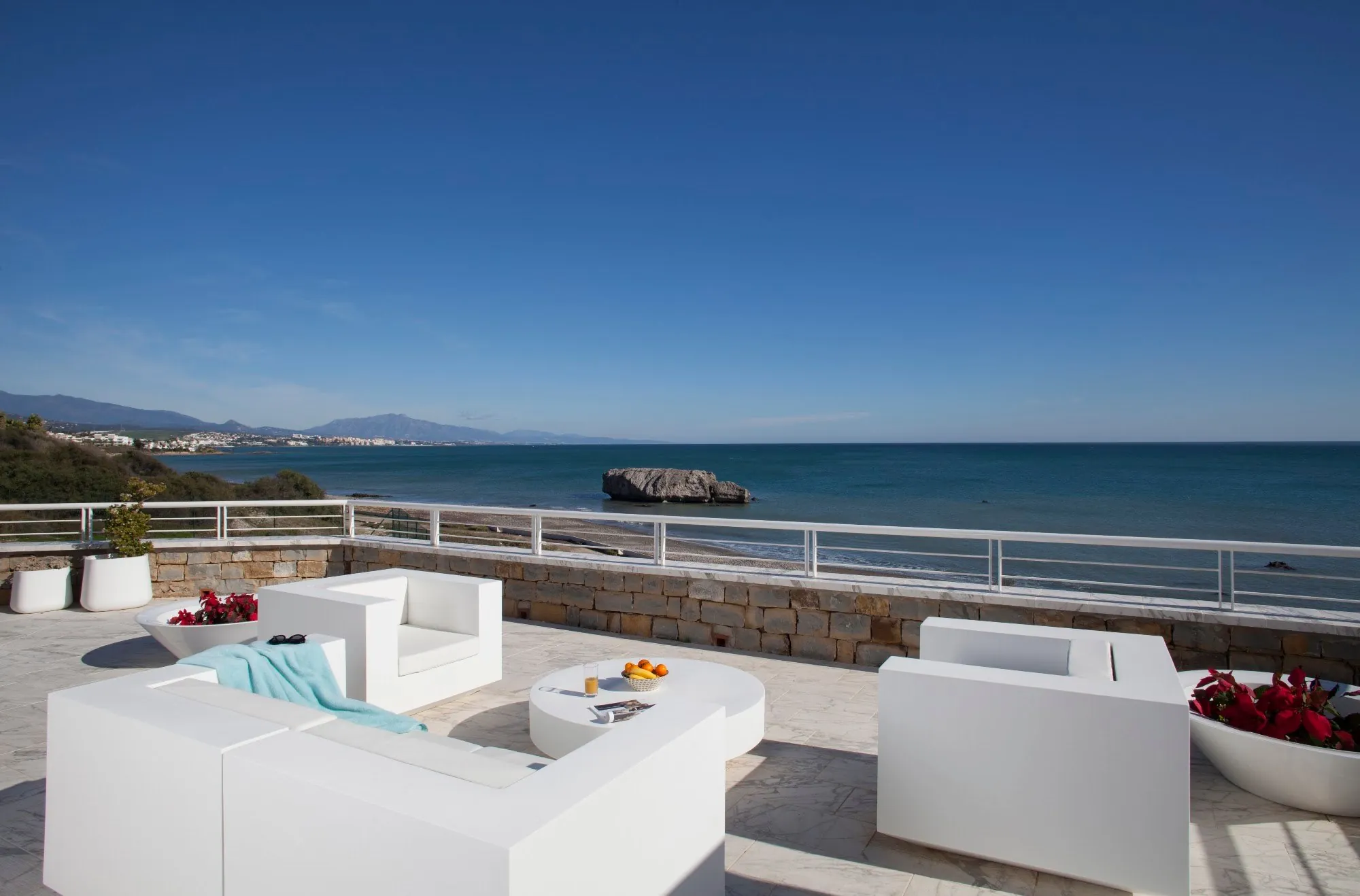 Terraza con sofás blancos frente al mar