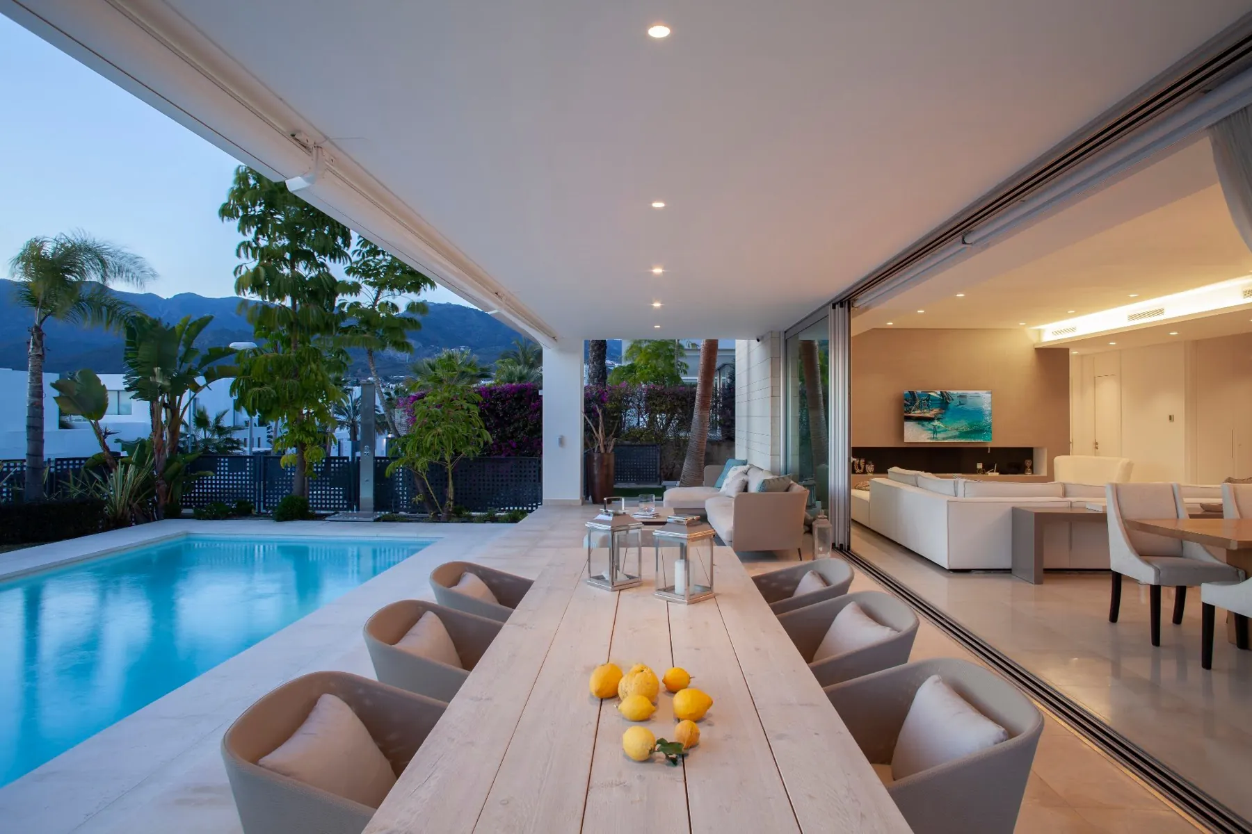 Porch with a long table beside a villa pool